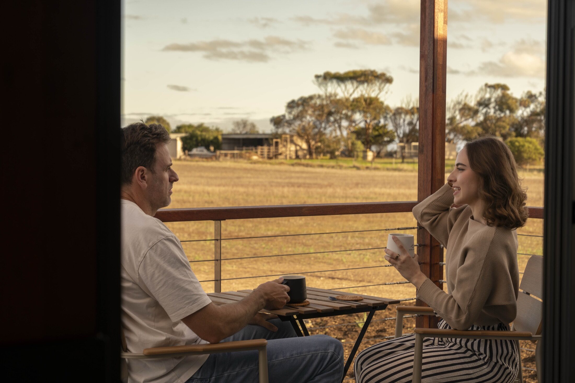 Guests on the deck of an AUTRA cabin at golden hour