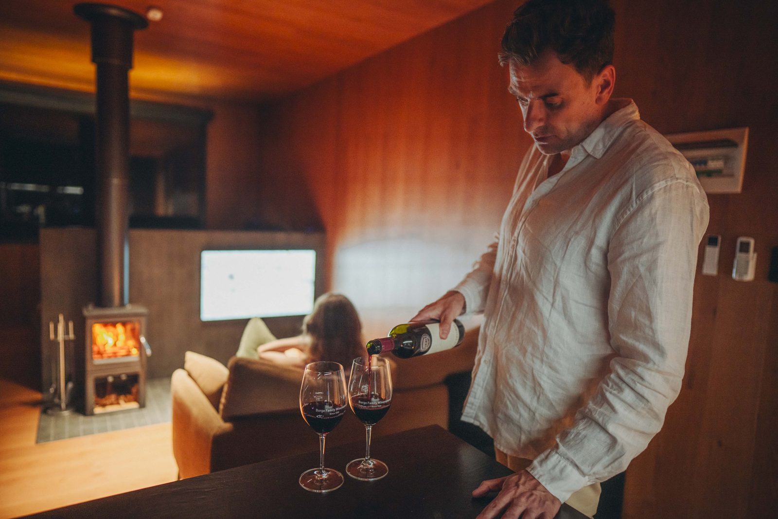 The wood fire and separate living area of a signature retreat, wine poured at the table